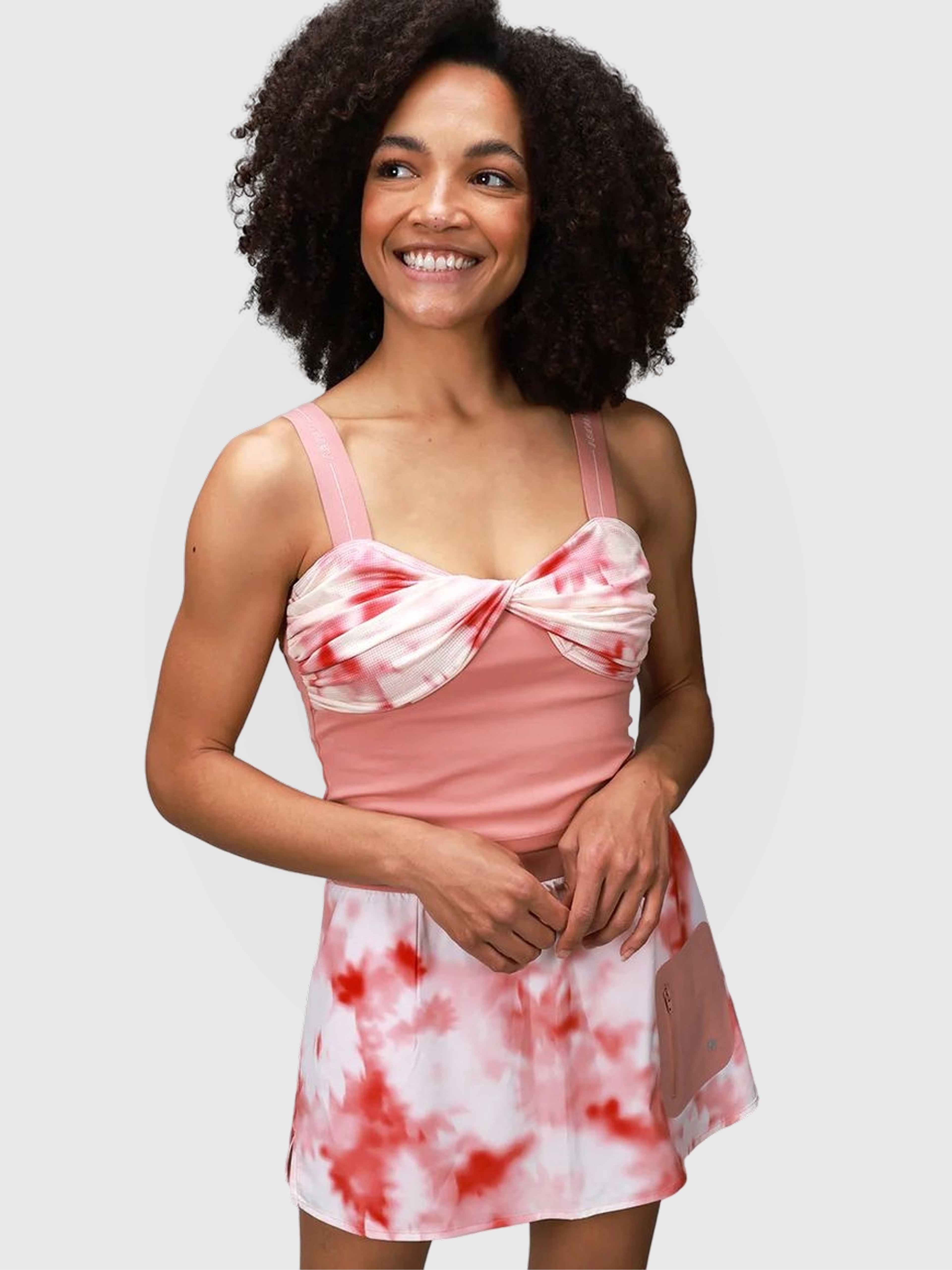 Woman wearing Pink Petal tie-dye skort with solid pink top for pickleball and padel apparel by MUEV