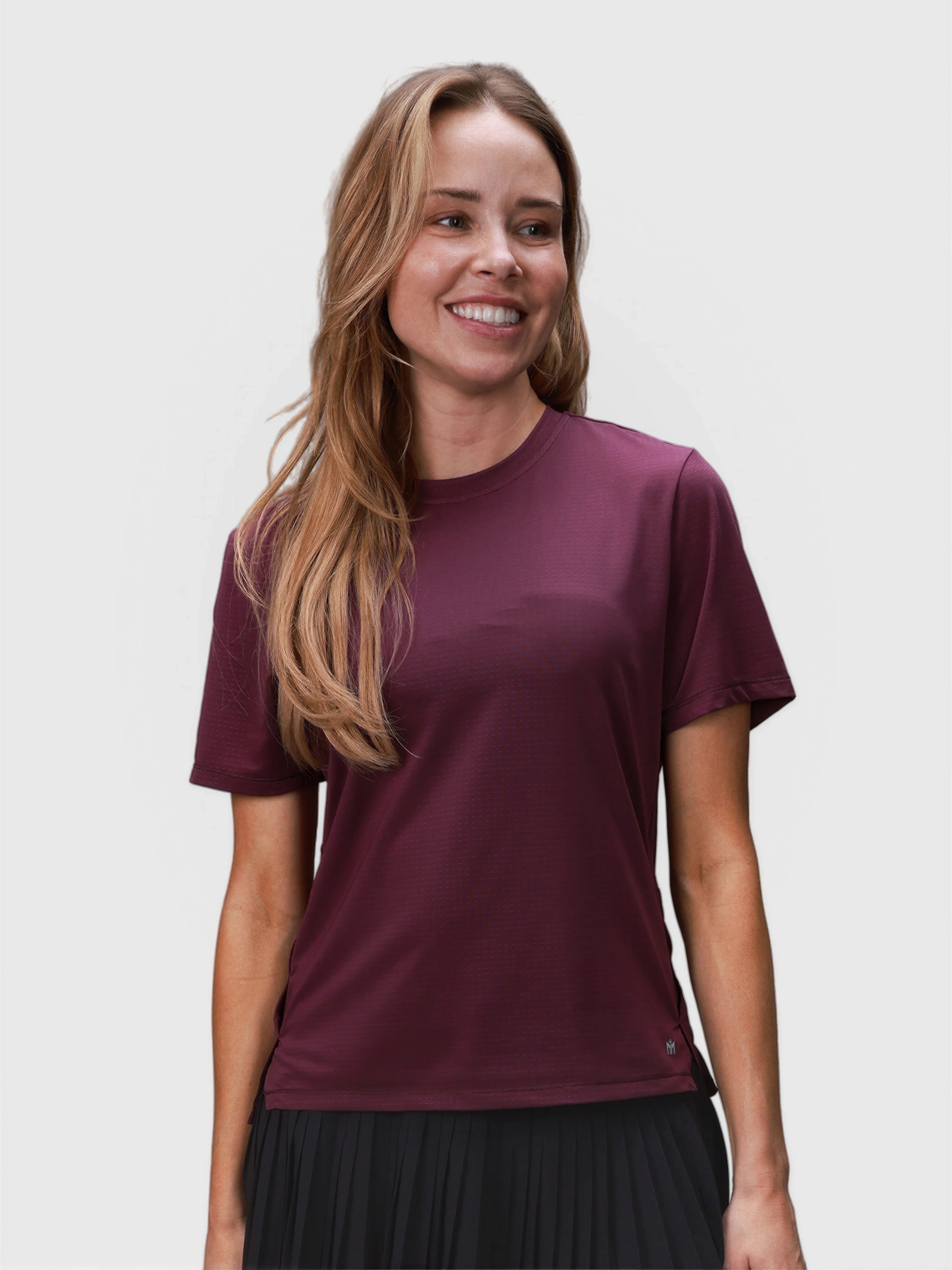 Woman smiling wearing plum-colored PowerMove Performance tee in pickleball clothing collection by MUEV front view