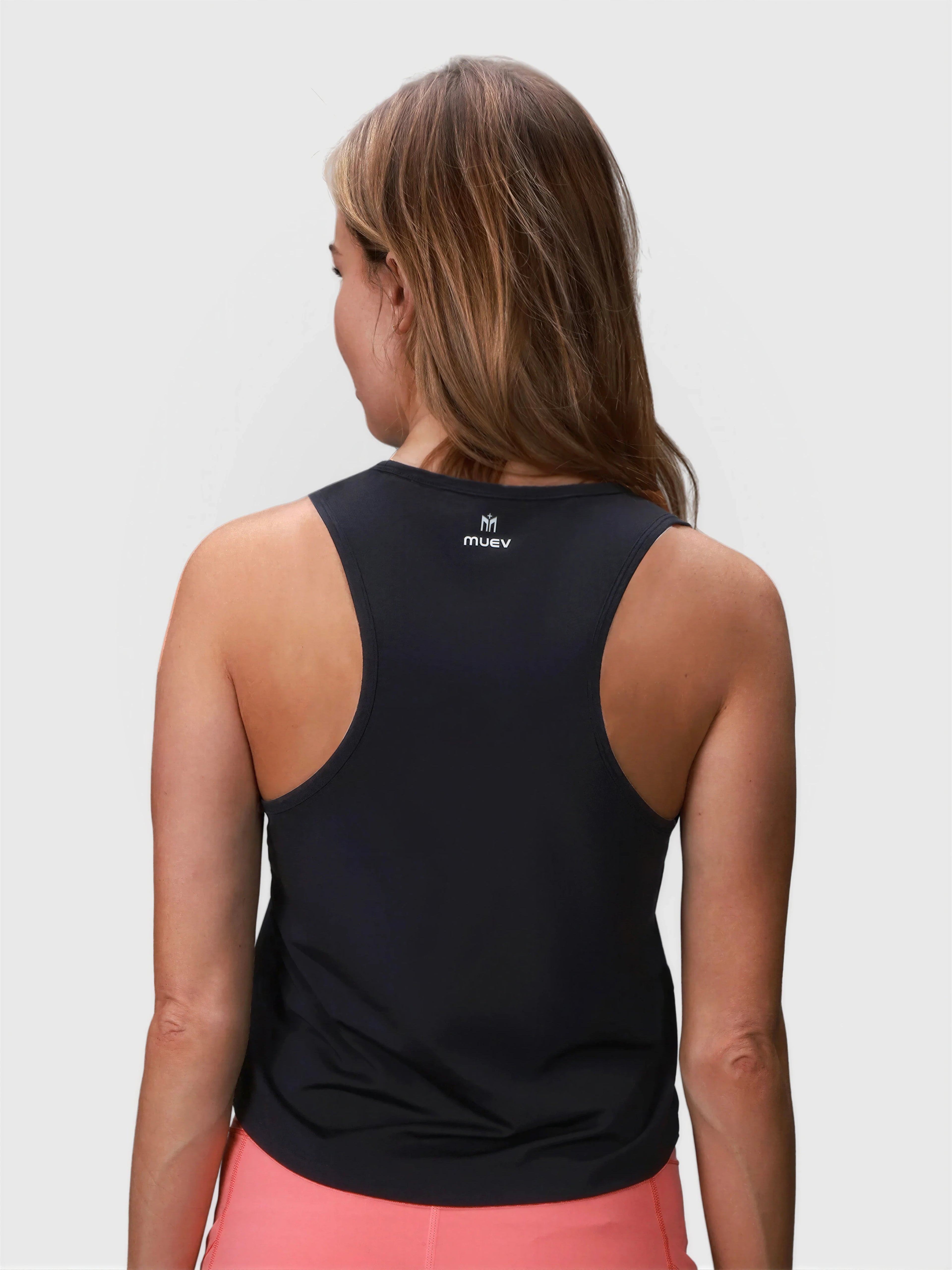 Woman shown from back wearing black Relaxed Tank by MUEV for padel and pickleball apparel with a relaxed fit