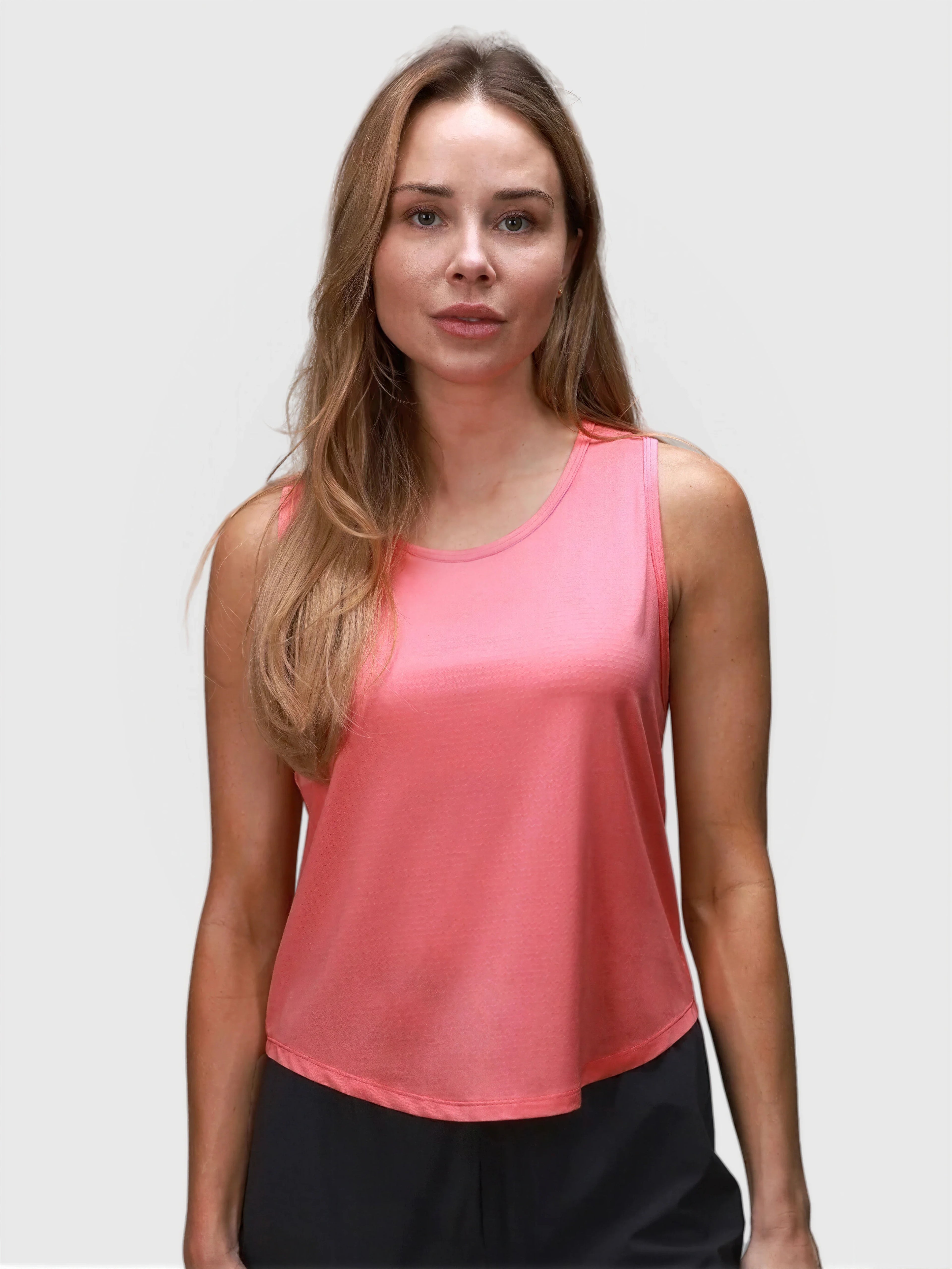 Woman wearing coral Relaxed Tank by MUEV designed for padel and pickleball apparel with a loose fit