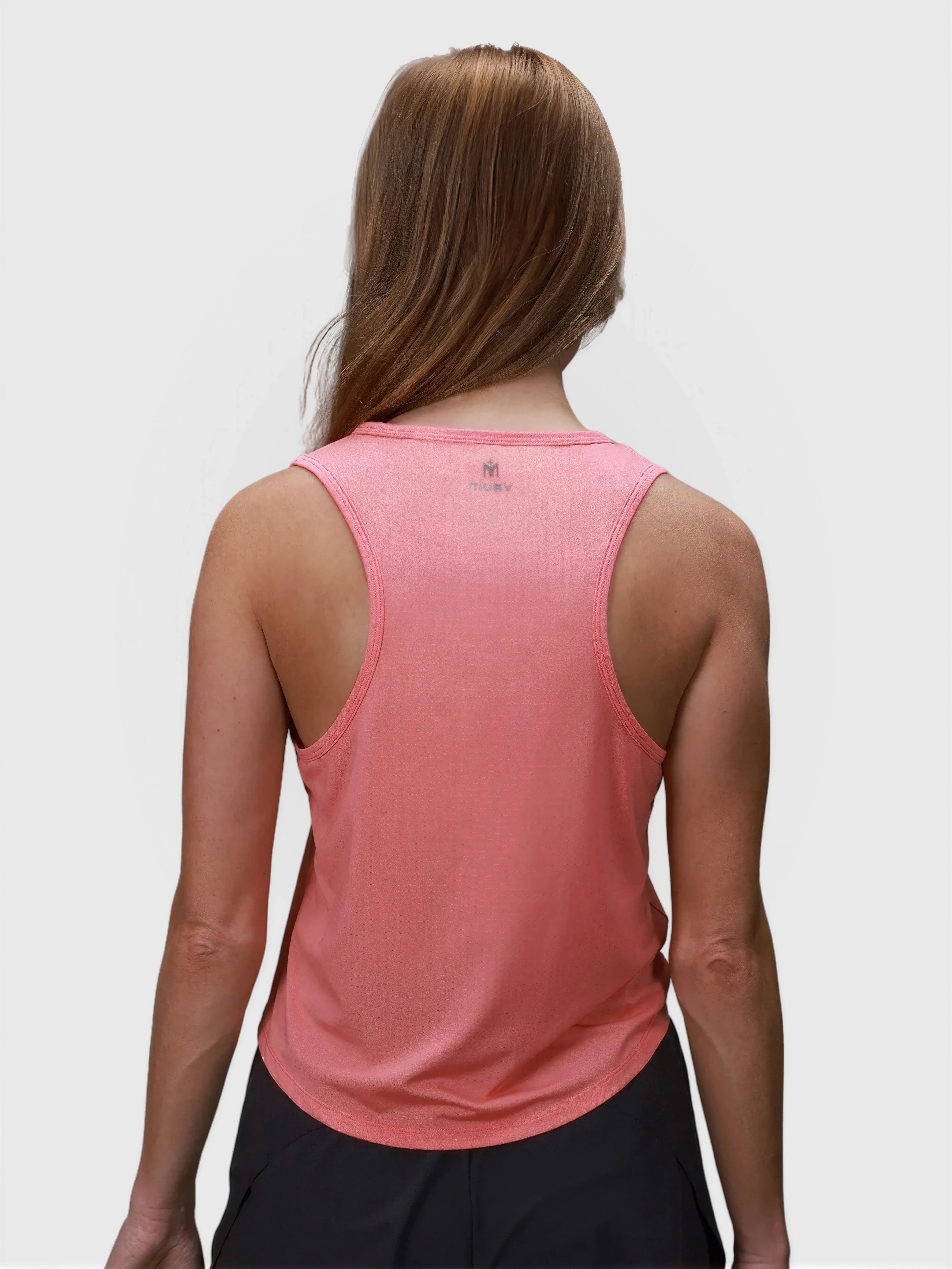 Woman shown from back wearing coral Relaxed Tank by MUEV for padel and pickleball clothing with a loose fit